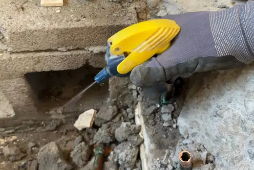 Technician using leak detection equipment around hidden plumbing related to Leak Detection in Monrovia