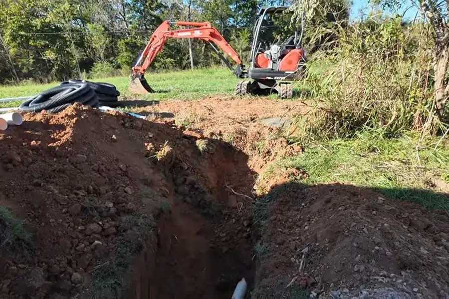 Open trench with new sewer pipe being installed in soil related to New sewer lateral connection in Monrovia