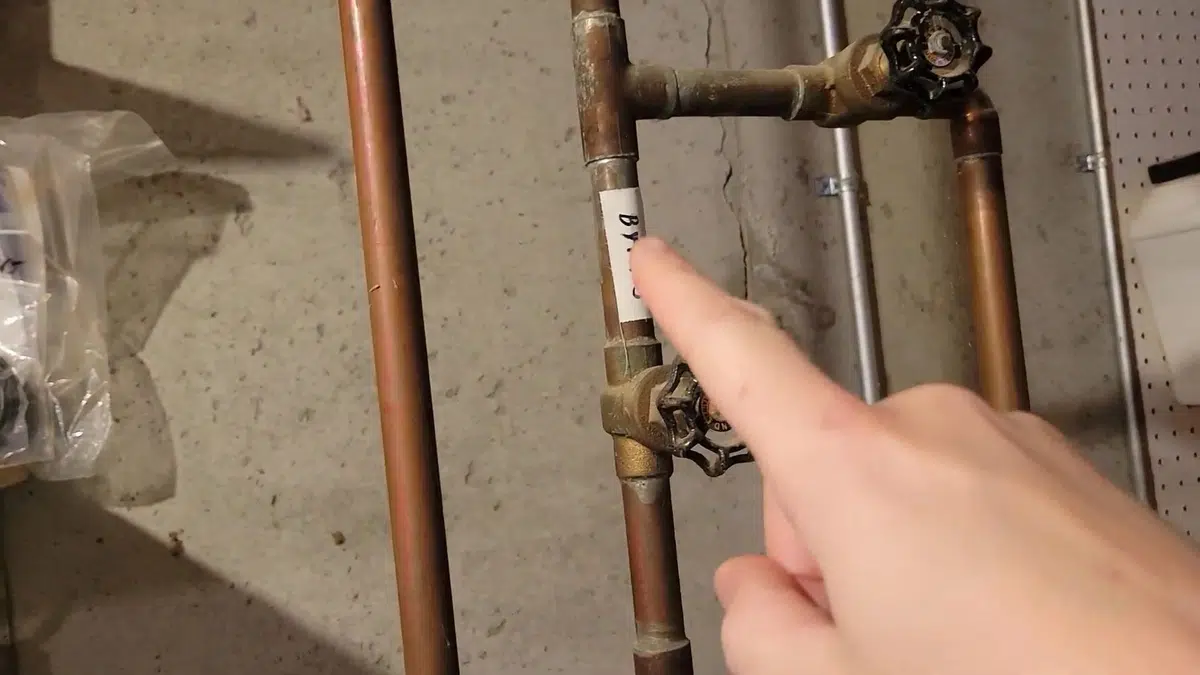 Plumber working on gas water heater piping and controls related to Monrovia Plumbing Pros plumber at a local heritage home